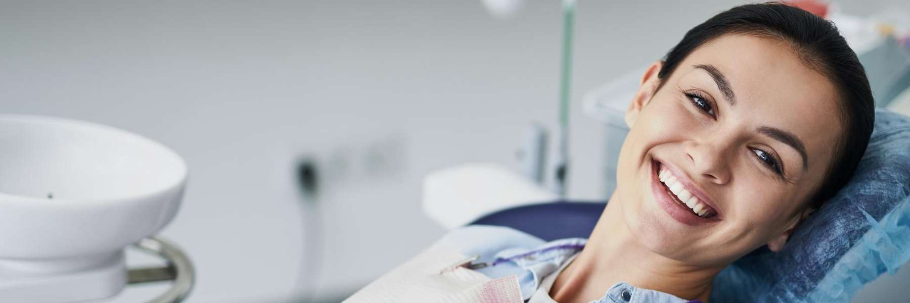 A woman smiling during a dental exam in Pacifica, CA