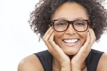A woman resting her face on her hands and smiling