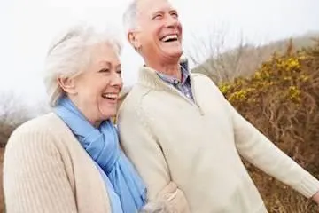 Elderly Couple smiling in an outdoor setting