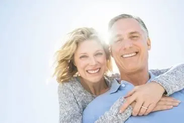 Elderly couple smiling in an outdoor setting