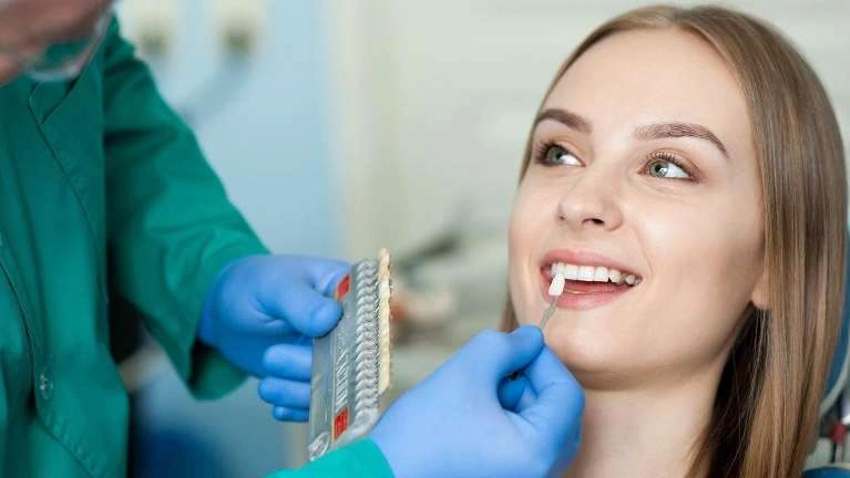 Woman smiling with a dentist nearby
