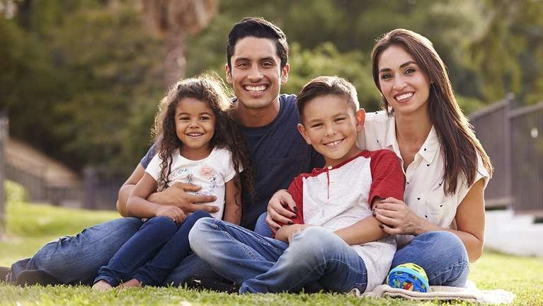 Multi generational family sitting on ground
