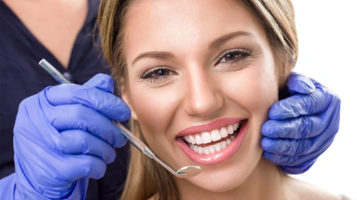 Woman smiling while being checked by a dentist
