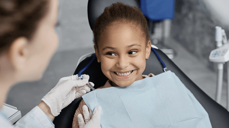 A child smiling at a dentist