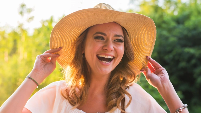 A woman wearing a hat and smiling