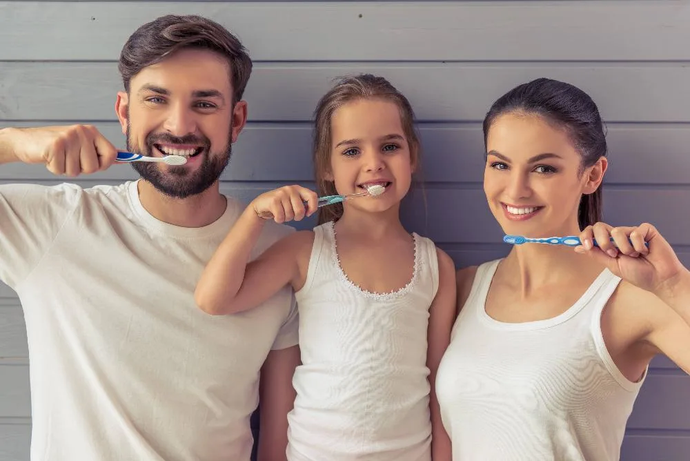 Family of three brushing their teeth