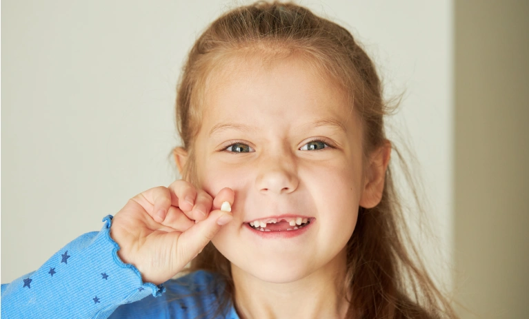 A kid holding a teeth