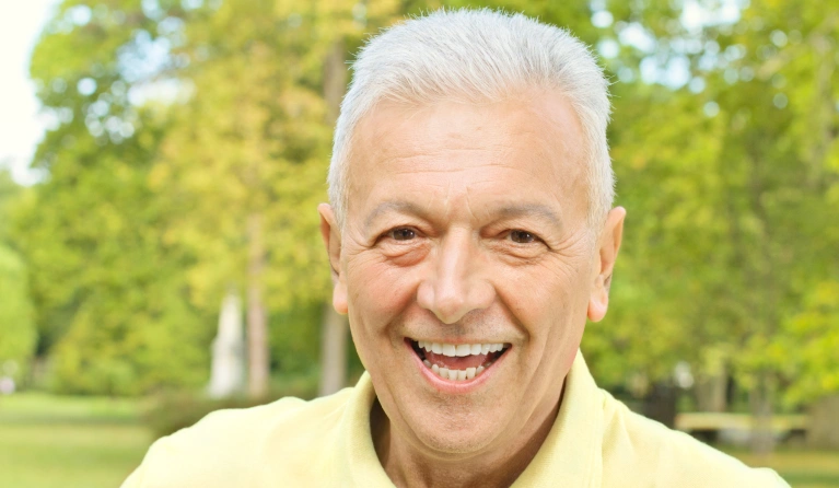 A man smiling in an outdoor setting