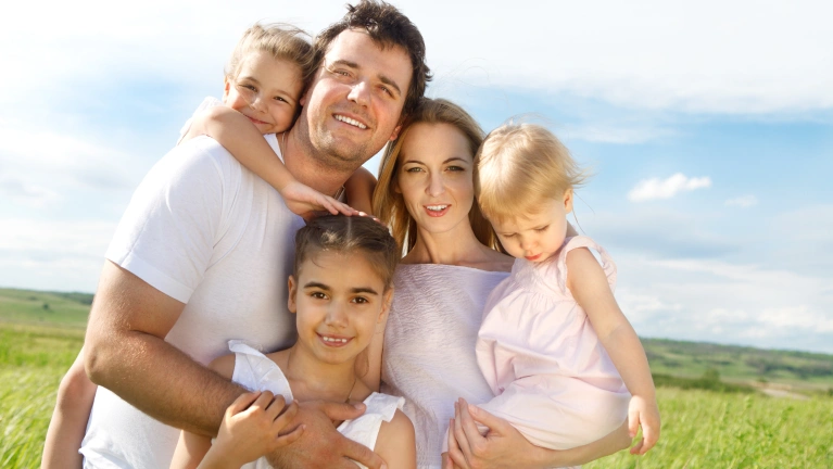 Family of five smiling posing for a photo
