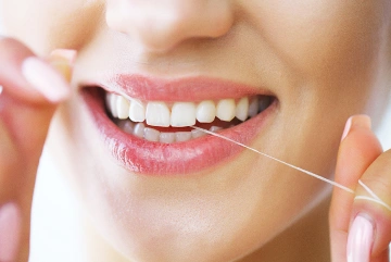 A woman flossing her teeth