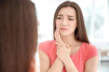 A woman holding her jaw in pain