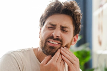 A man holding his jaw in pain