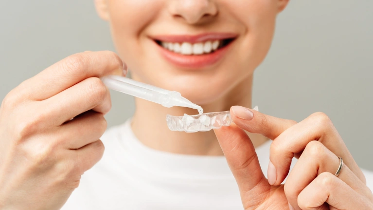 A woman holding an invisalign clear aligner