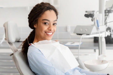 A woman smiling while sitting in a dental chair
